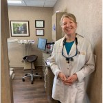 Photo of Dr. Philips standing & smiling in an operative room at Tonka Smiles [CITY] [STATE]