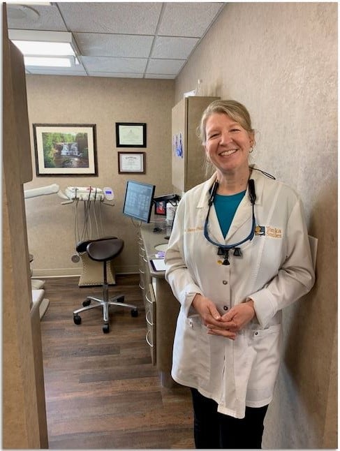 Photo of Dr. Philips standing & smiling in an operative room at Tonka Smiles [CITY] [STATE]