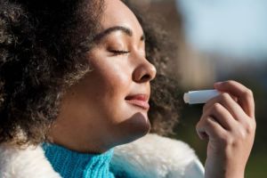 woman putting chapstick on lips