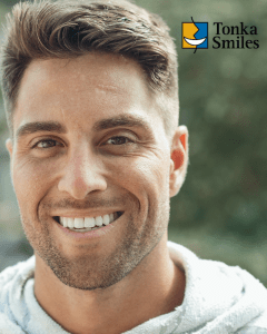 Man smiling in grey sweatshirt with implants